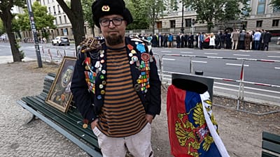iemion Skrepetsky, pozuje do zdjęcia z jednym ze swoich obrazów w pobliżu ambasady rosyjskiej w Berlinie w Niemczech w piątek, 12 czerwca 2026 roku.