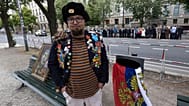 Semyon Skrepetsky posa para uma fotografia com um dos seus quadros junto à Embaixada da Rússia em Berlim, a 12 de junho de 2026