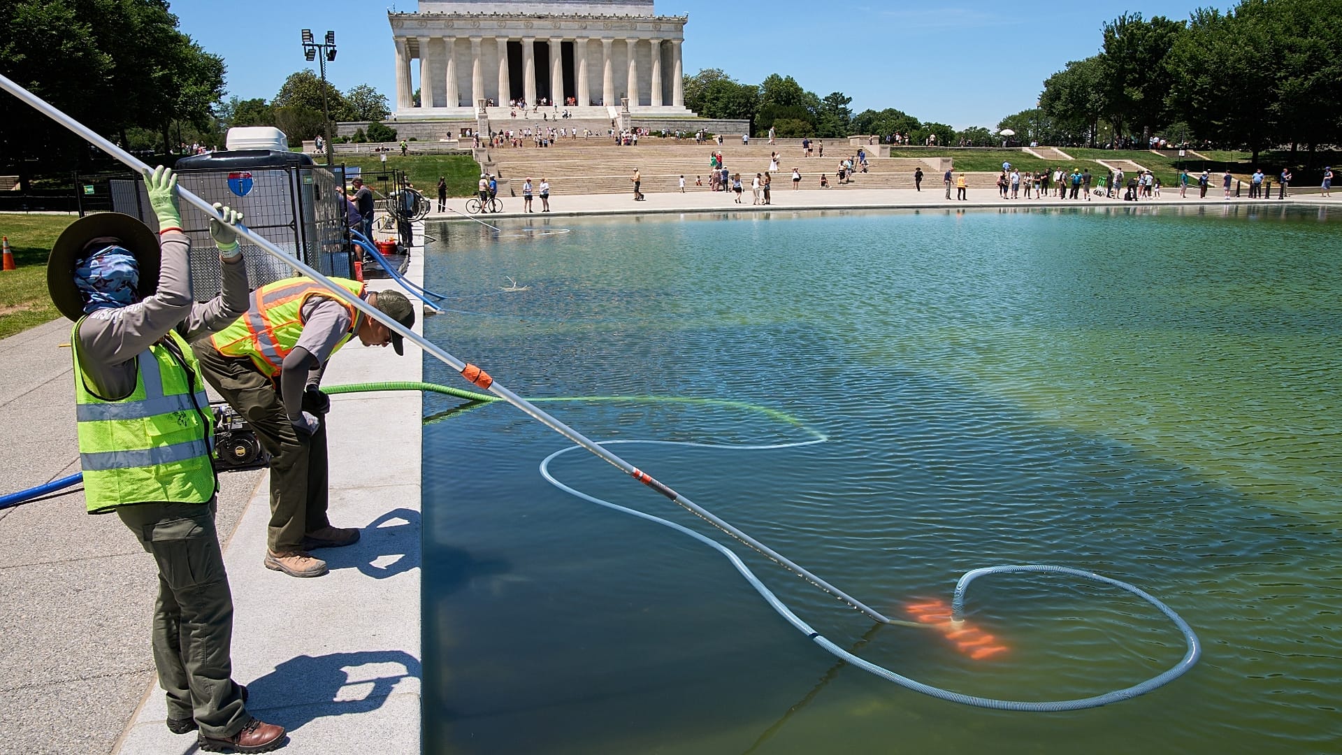 Trabajadores del Servicio de Parques Nacionales limpian algas del estanque reflectante del Monumento a Lincoln