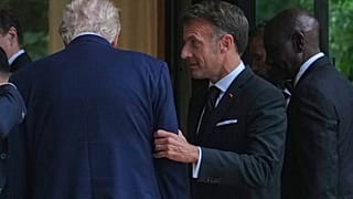 Emmanuel Macron tient le bras de Donald Trump après une photo de groupe des dirigeants lors du sommet du G7, mardi 16 juin 2026, à Évian-les-Bains, en France.