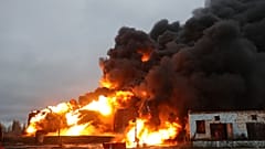 Горящие резервуары после обстрела украинскими силами российской нефтебазы в оккупированном Шахтёрске на востоке Украины, четверг, 27 октября 2022 года.