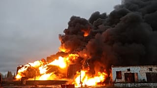 Горящие резервуары после обстрела украинскими силами российской нефтебазы в оккупированном Шахтёрске на востоке Украины, четверг, 27 октября 2022 года.