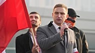 Lider skrajnej prawicy, Robert Bakiewicz, przemawia na początku dorocznego marszu z okazji Dnia Niepodległości w Warszawie, w czwartek 11 listopada 2021 r.