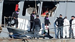 Migrants disembark from the Italian navy ship Libra at the port of Shengjin, where Italy set up a center similar to a return hub