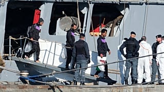 Μετανάστες αποβιβάζονται από το ιταλικό πολεμικό πλοίο Libra στο λιμάνι Σενγκίν, όπου η Ιταλία έχει δημιουργήσει κέντρο παρόμοιο με κόμβο επιστροφής