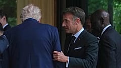 Emmanuel Macron trzyma Donalda Trumpa pod ramię po wspólnej fotografii przywódców podczas szczytu G7 we wtorek 16 czerwca 2026 roku w Évian-les-Bains we Francji.