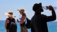  A tourist drinks water on a hot day at the beach in Barcelona, Spain, July 2, 2025.