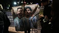 A fan holds a poster of soccer stars Lionel Messi and Diego Maradona after watching the World Cup soccer match between Argentina and Algeria in Buenos Aires,