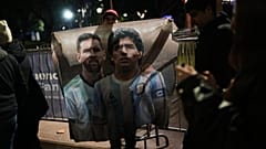 A fan holds a poster of soccer stars Lionel Messi and Diego Maradona after watching the World Cup soccer match between Argentina and Algeria in Buenos Aires,