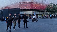FILE: Policemen walk in front of a huge banner showing Iranian flag at the Islamic Revolution square in Tehran, 14 June 2026