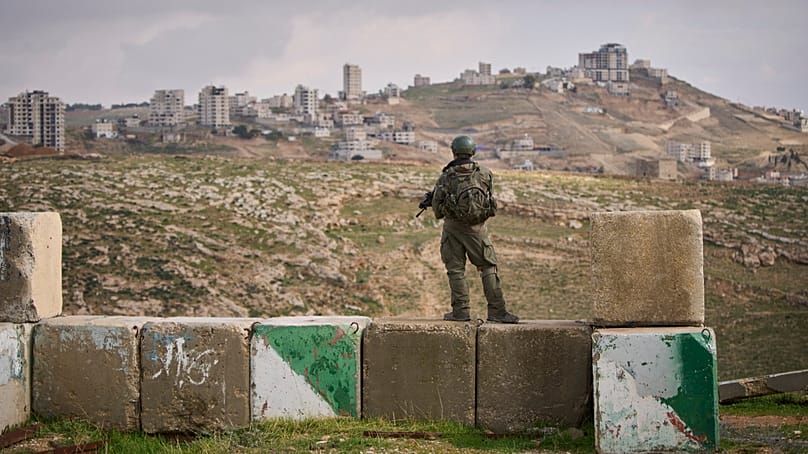 An Israeli soldier stands guard during the inauguration ceremony for the newly legalized Jewish settlement of Yatziv. (AP Photo/Ohad Zwigenberg)