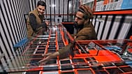 An Afghan shopkeeper shows a smartphone to a customer in Kabul, 12 February, 2016