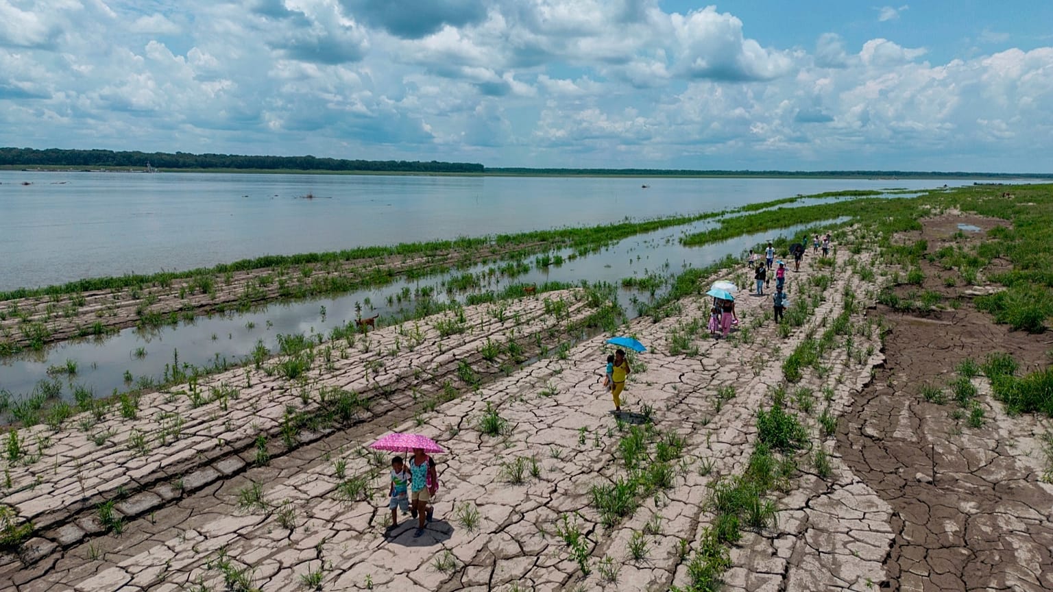 Des personnes traversent une portion de l’Amazone frappée par la sécheresse à Santa Sofia, en périphérie de Leticia, en Colombie, le 20 octobre 2024.