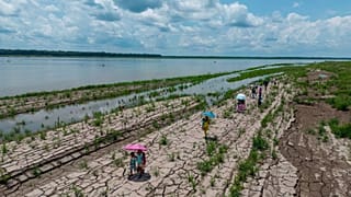 Varias personas caminan por una zona del río Amazonas que muestra señales de sequía en Santa Sofía, en las afueras de Leticia, Colombia, el 20 de octubre de 2024.