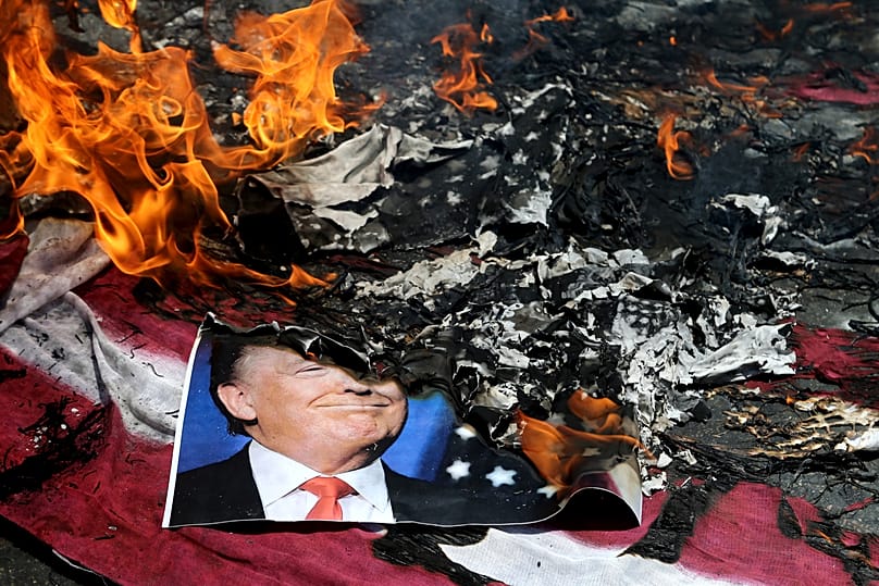 Donald Trump amerikai elnököt ábrázoló plakátot gyújtanak fel egy teheráni tüntetésen, 2018. június 8-án