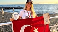 İtalya'da elde ettiği tarihi başarının ardından milli yüzücü Eda Savcıgil, Türk bayrağı ile poz veriyor.