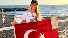 İtalya'da elde ettiği tarihi başarının ardından milli yüzücü Eda Savcıgil, Türk bayrağı ile poz veriyor.