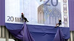 Alpinisten seilen sich vom EZB-Hochhaus ab und enthüllen riesige Nachbildungen der neuen Euro-Scheine – kurz nach der offiziellen Vorstellung der Währung.