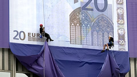 Mountaineers abseil from the European Central Bank highrise building to unveil huge replicas of the new euro banknotes, following the official presentation of the new currency