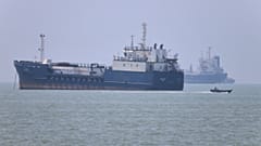 Небольшой моторный катер проходит мимо стоящих на якоре судов в Ормузском проливе у Бендер-Аббаса, Иран, среда, 17 июня 2026 года.