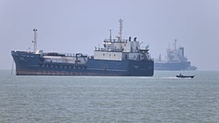 A small motorboat passes anchored vessels in the Strait of Hormuz off Bandar Abbas, Iran, Wednesday, June 17, 2026