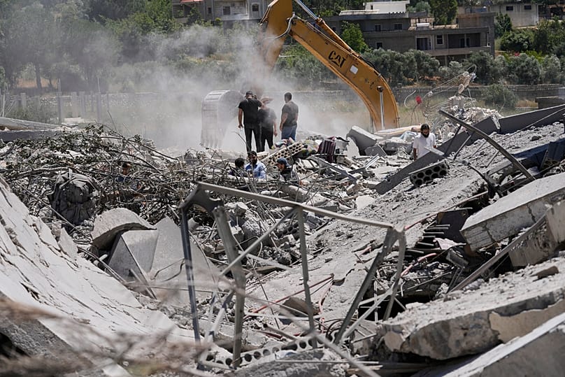 People use an excavator as they search for dead bodies under the wreckage of a destroyed house in the southern village of Touline, Lebanon, Tuesday, June 16, 2026