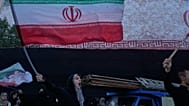امرأة تلوح بالأعلام الإيرانية وهي تهتف بشعارات ضد المحادثات الإيرانية والأمريكية في ساحة الثورة الإسلامية في طهران، إيران، الأحد 14 يونيو 2026. (AP Photo/فاهد سليمي)