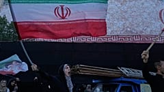 امرأة تلوح بالأعلام الإيرانية وهي تهتف بشعارات ضد المحادثات الإيرانية والأمريكية في ساحة الثورة الإسلامية في طهران، إيران، الأحد 14 يونيو 2026. (AP Photo/فاهد سليمي)