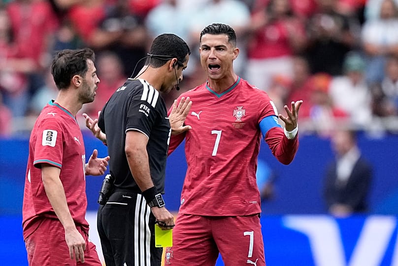 Portugal's Cristiano Ronaldo argues with referee Abdulrahman Al-Jassim, of Qatar, after he showed a yellow card to Bernardo Silva, during Group K soccer match against DR Congo