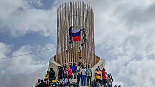 FILE - Supporters of Niger's ruling junta hold a Russian flag in Niamey, Niger, on Aug. 3, 2023.