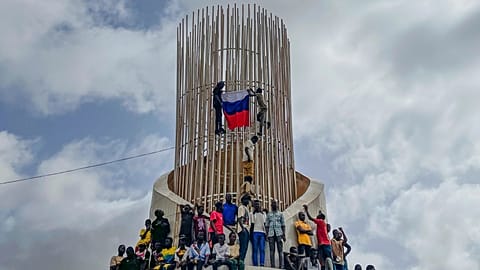 FILE - Supporters of Niger's ruling junta hold a Russian flag in Niamey, Niger, on Aug. 3, 2023.