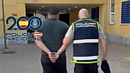 Un agente escolta a uno de los 17 sospechosos detenidos en el marco de la operación.