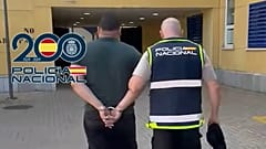 Un agente escolta a uno de los 17 sospechosos detenidos en el marco de la operación.