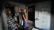 Resident Samih Haidar reacts as he inspects his burned apartment damaged in Israeli strikes