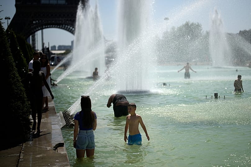 Les gens viennent se rafraîchir dans les fontaines des jardins du Trocadéro à Paris, archives