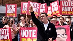 Im Wahlkreis Makerfield gestikuliert Labour-Kandidat Andy Burnham im Stubshaw Cross Community and Sports Club, umringt von Unterstützern, während die Nachwahl läuft.