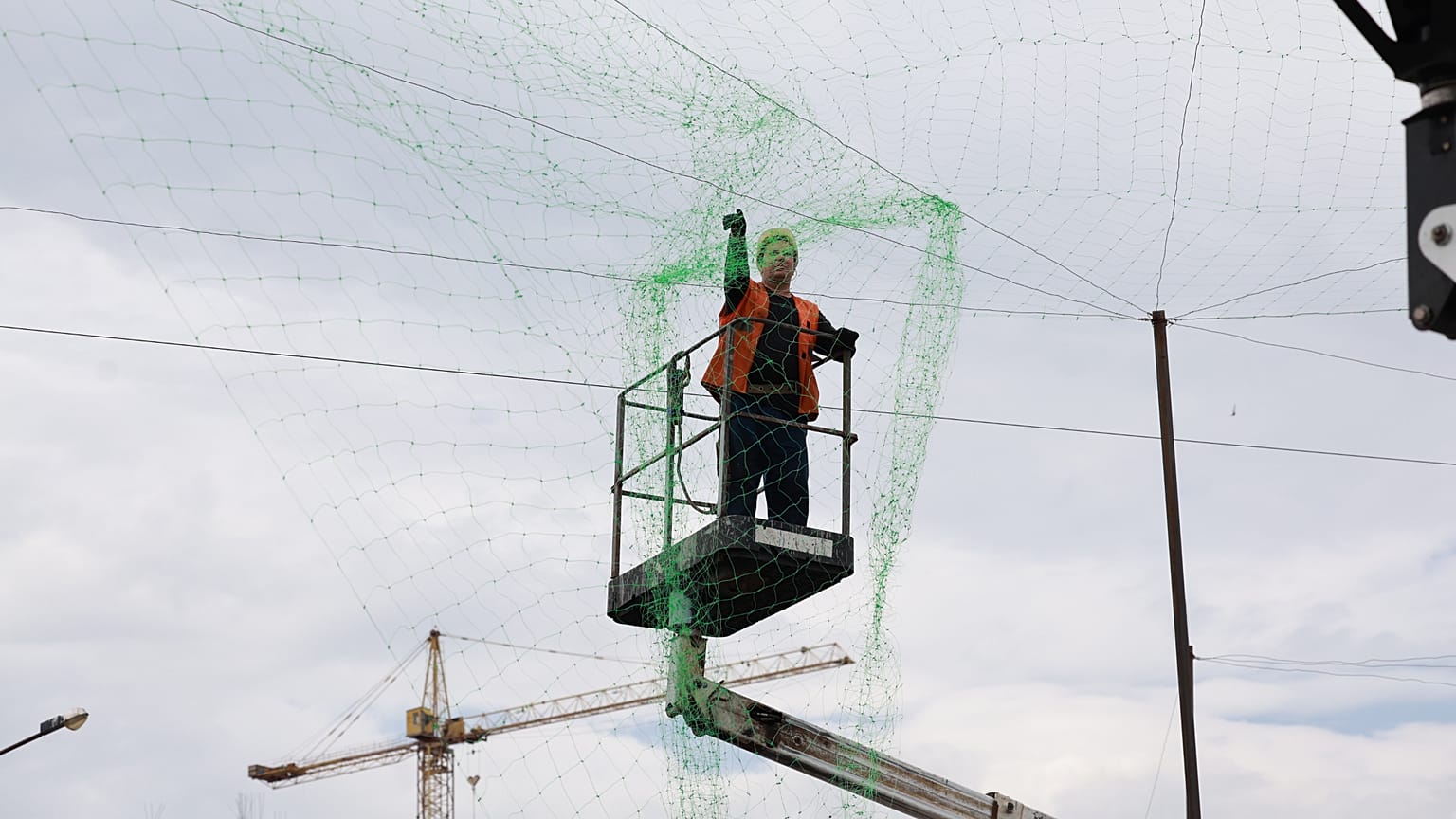 A municipal worker installs anti drone net to prevent Russian attacks on people and transport in Zaporizhzhia, Ukraine, Thursday, June 18, 2026.