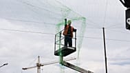 A municipal worker installs anti drone net to prevent Russian attacks on people and transport in Zaporizhzhia, Ukraine, Thursday, June 18, 2026.