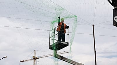 Un employé municipal installe un filet anti-drones pour protéger la population et les transports à Zaporijjia, en Ukraine, jeudi 18 juin 2026.