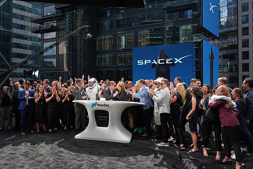 Des employés de SpaceX célèbrent lors de la cérémonie de la cloche de clôture de l'IPO au Nasdaq MarketSite, à New York, le 12 juin 2026