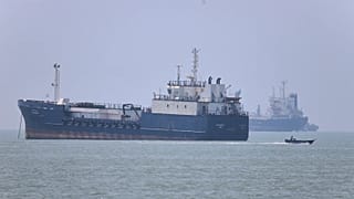 A small motorboat passes anchored vessels in the Strait of Hormuz off Bandar Abbas, Iran, Wednesday, June 17, 2026.
