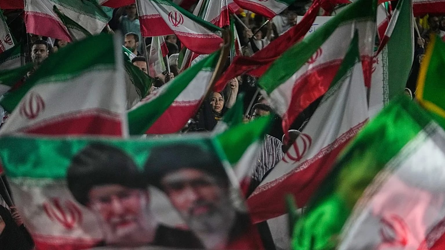 ARŞİV: Tahran’da bir meydandaki mitingde, rejim yanlısı göstericiler İran bayrakları ile Ayetullah Mücteba Hamaney ve öldürülen babasının portresini sallıyor, 29 Mayıs 2026