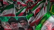 ARŞİV: Tahran’da bir meydandaki mitingde, rejim yanlısı göstericiler İran bayrakları ile Ayetullah Mücteba Hamaney ve öldürülen babasının portresini sallıyor, 29 Mayıs 2026