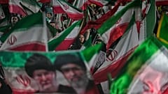 ARŞİV: Tahran’da bir meydandaki mitingde, rejim yanlısı göstericiler İran bayrakları ile Ayetullah Mücteba Hamaney ve öldürülen babasının portresini sallıyor, 29 Mayıs 2026