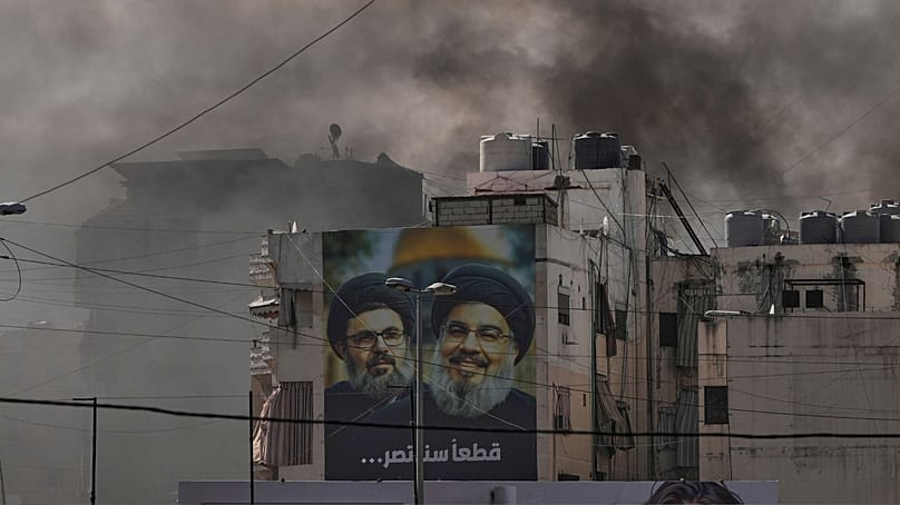 تصاویر حسن نصرالله (راست) و پسرعمویش، هاشم صفی‌الدین، در کنار دود پس از حمله هوایی اسرائیل به ضاحیه، حومه جنوبی بیروت، لبنان، ۳۰ مارس ۲۰۲۶