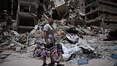 يحمل الحلاق وسام سرور، 41 عامًا، دراجة ابنته التي تم انتشالها من صالون الحلاقة الخاص به أثناء بحثه عن متعلقاته تحت أنقاض المتجر الذي تضرر في غارة إسرائيلية في مدينة صور الساحل