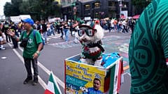A dog named Osito wears a Mexico national team jersey and rides in a bicycle basket of Jorge Rangel 
