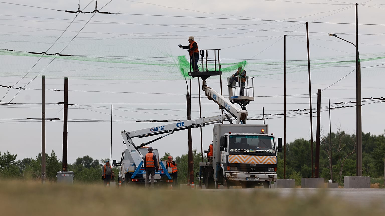 Municipal workers install anti drone nets to prevent Russian attacks on people and transport in Zaporizhzhia, Ukraine, Thursday, June 18, 2026.