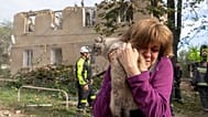 Une femme tient son chat dans ses bras après des opérations de recherche et de sauvetage menées dans l'immeuble résidentiel suite à l'attaque russe à Kharkiv, 20.06.2026