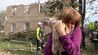 Une femme tient son chat dans ses bras après des opérations de recherche et de sauvetage menées dans l'immeuble résidentiel suite à l'attaque russe à Kharkiv, 20.06.2026